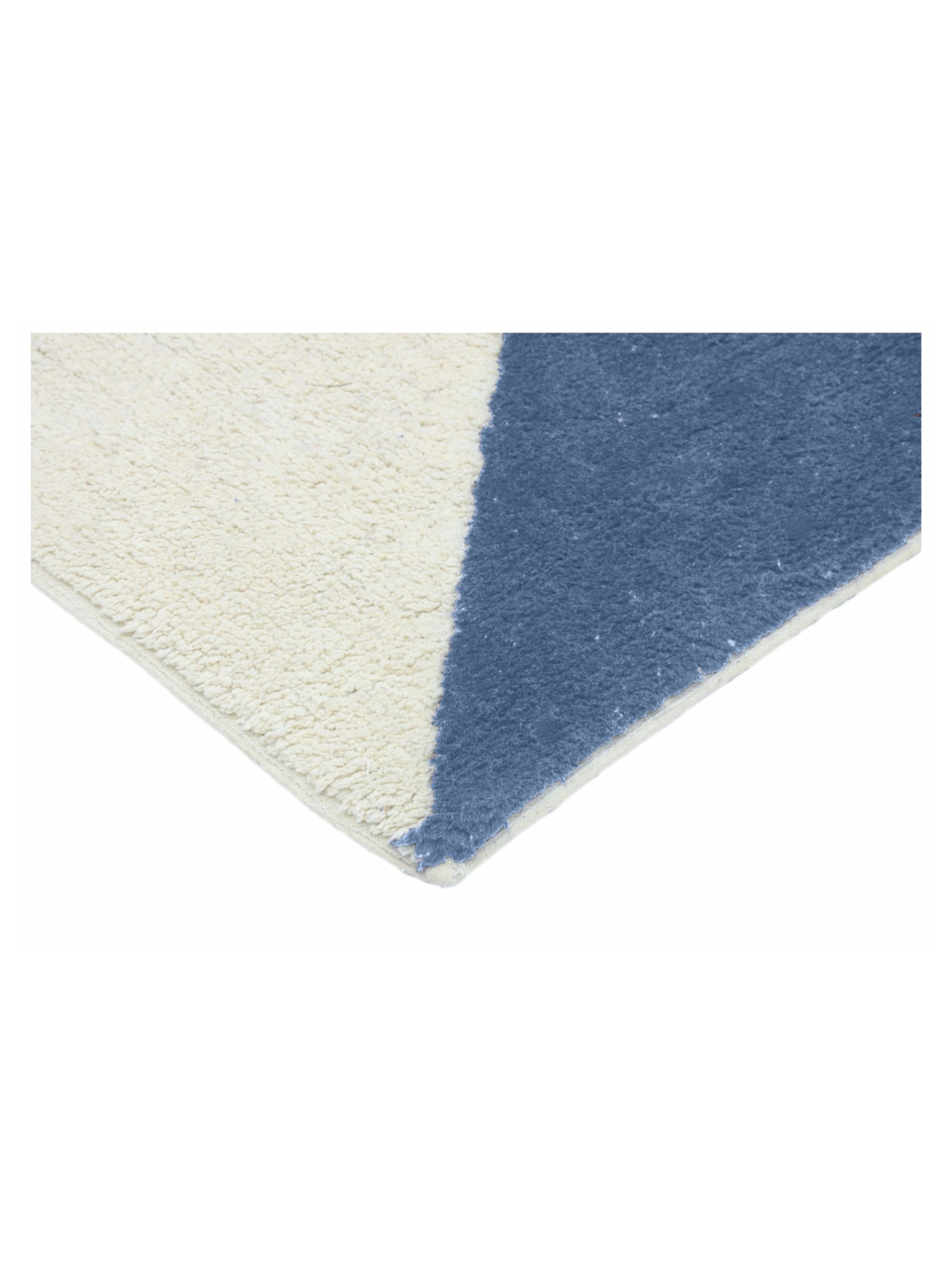 Corner of a rug with white and blue geometric pattern on a white background