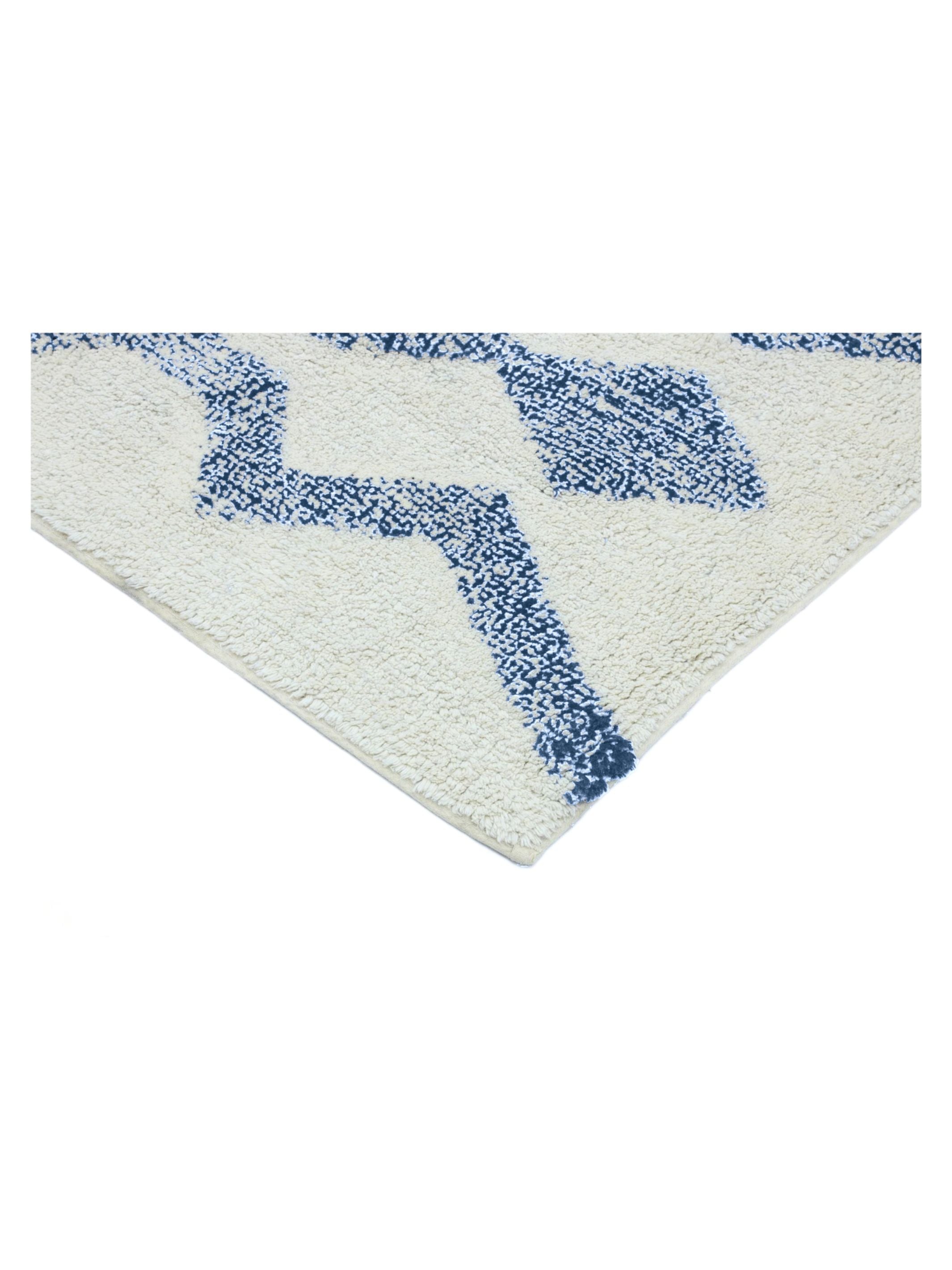 Corner of a textured rug with blue pattern on a white background