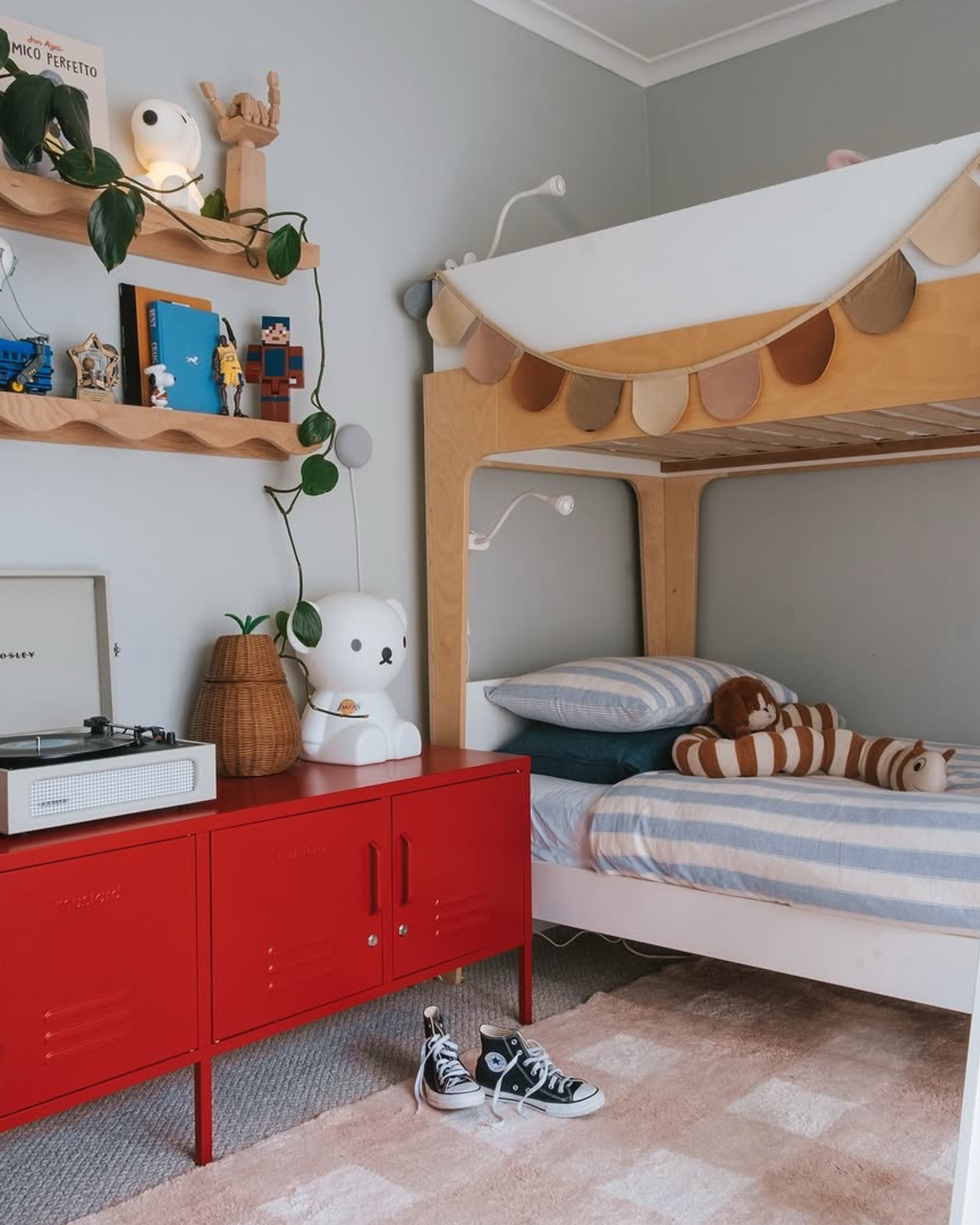 Children's room with a bunk bed, red cabinet, and record player.